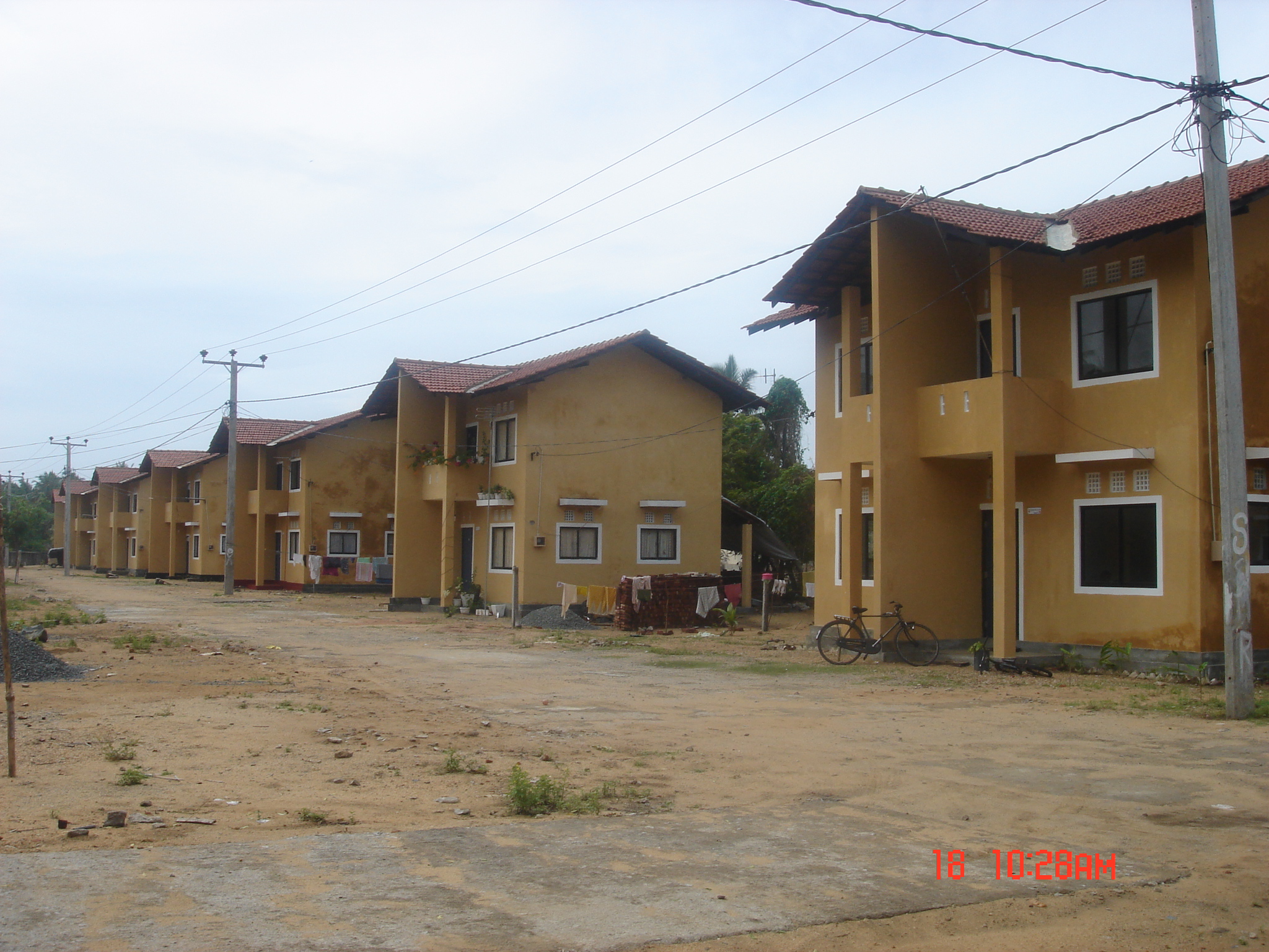 Row of modern yellow residential houses with tiled roofs.