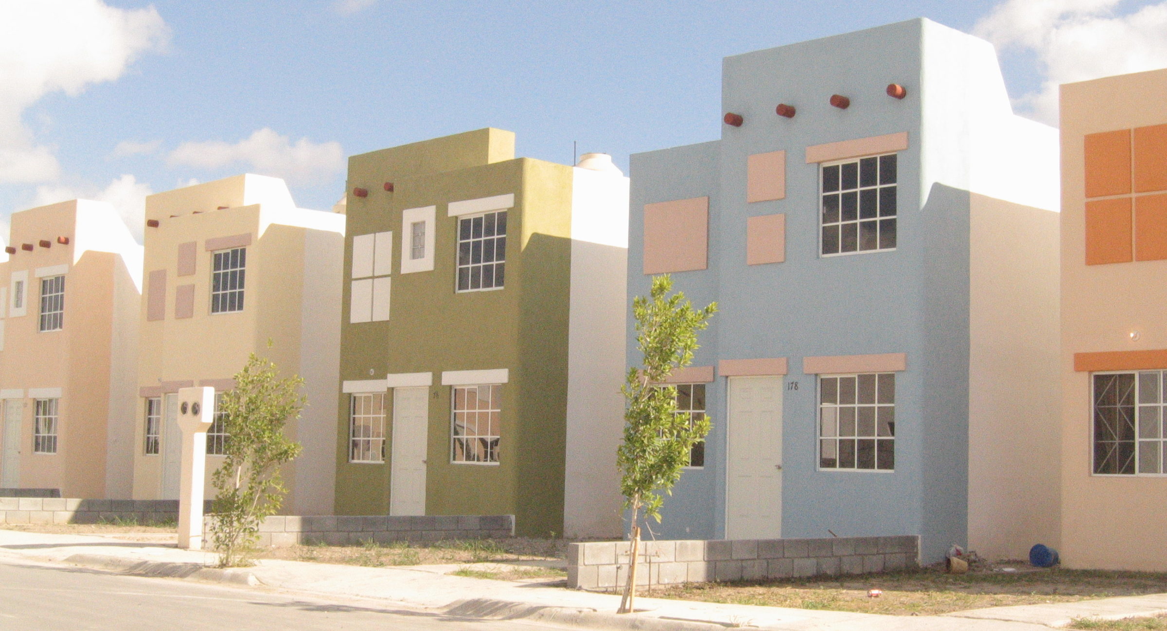 Row of modern two-story suburban houses with pastel colors.