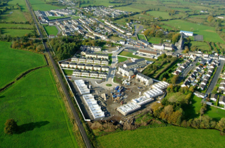 Aerial view of a rural village with clustered houses and green fields.