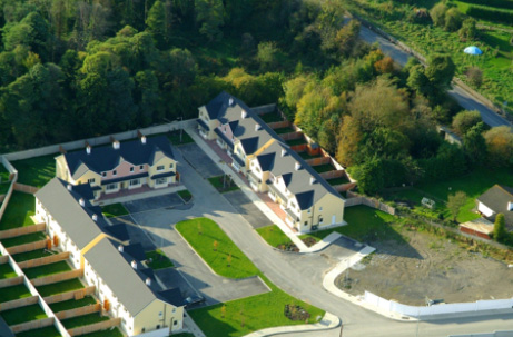 Aerial view of a residential area with multiple houses and greenery.