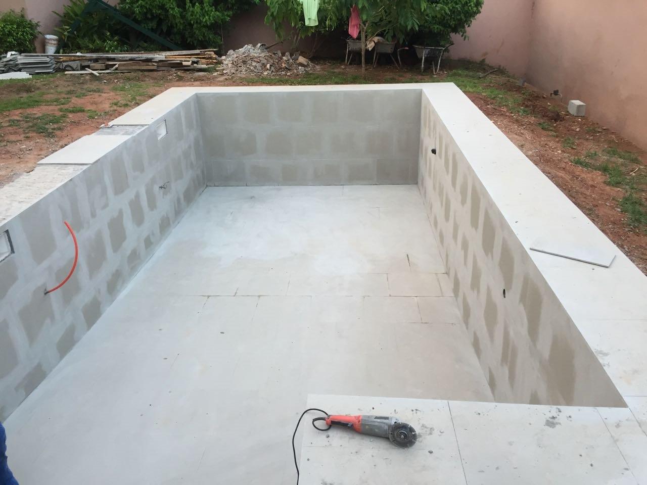 Unfinished backyard swimming pool under construction.